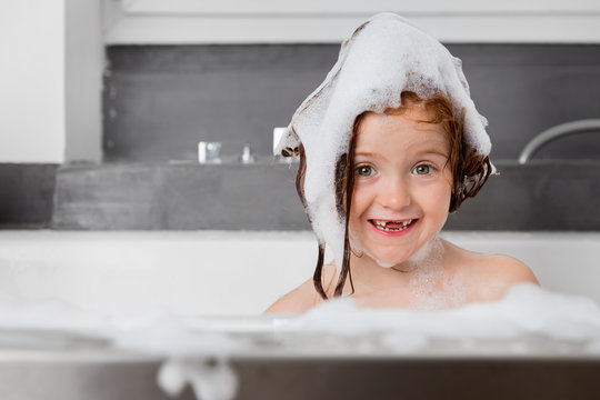 Portrait of girl with foam on top of head in bath