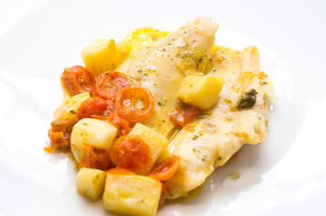 fish dish, cod with tomato, potatoes and capers, cooked in a pan.