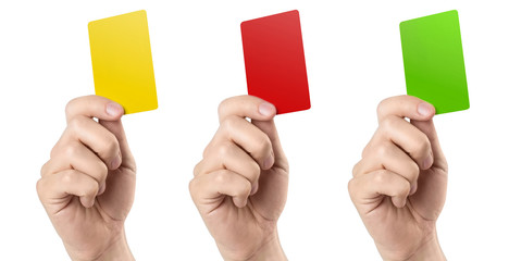 Male football (soccer) referee hand holding yellow, red and green cards, isolated on white background