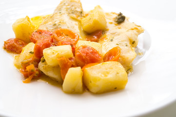fish dish, cod with tomato, potatoes and capers, cooked in a pan.