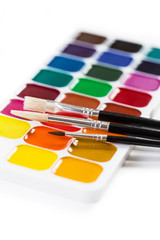 Set of a new watercolor paint and three brushes, isolated on white background