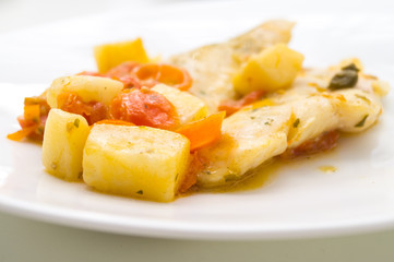 fish dish, cod with tomato, potatoes and capers, cooked in a pan.