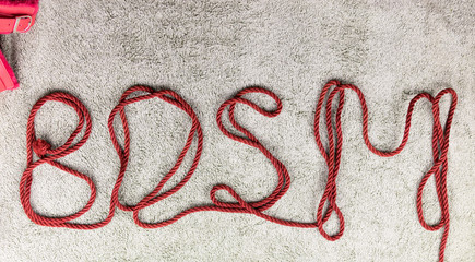 BDSM. The letters are laid out of the rope for bindings (shibari).