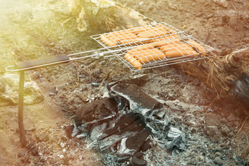 Sausages on the grill on a picnic in the campaign. Toned.