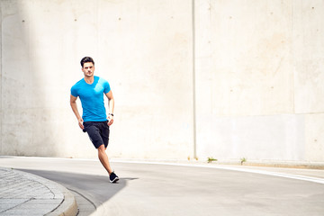 Athletic and handsome man jogging in the city. Sport and fitness concept