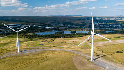 Wind turbines on a rural hillside next to a large lake