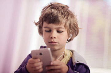 Little boy playing games on smart phone.
