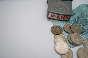 Paid stamp, banknotes and coins of Ringgit Malaysia on white background isolated.Selective focus. Copy space. Currency, economy, saving and financial concept.