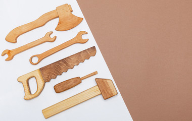 view from above on a wooden hand-made set with tools for the child. A wooden hammer, a saw, a wrench, a screwdriver, an ax are toys for a boy. flat lay with place for text