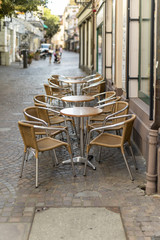Fototapeta na wymiar Tische und Stühle vor einem Cafe in der Fußgängerzone Baden-Baden
