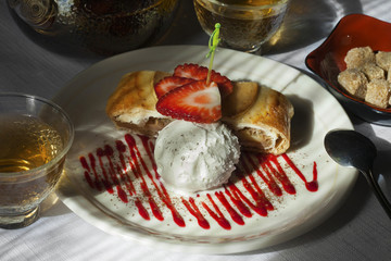 Delicious strudel with ice cream and strawberry in the window light