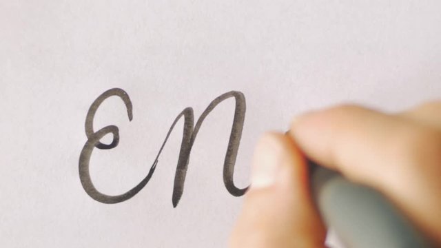 Hand writing the words END and then THE on white paper