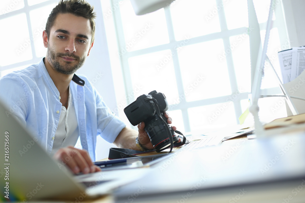 Aufkleber portrait of young designer sitting at graphic studio in front of laptop and computer while working o