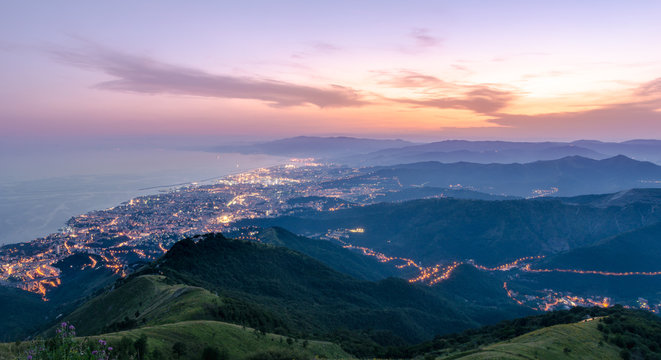 Panoramic image at golden hour, mountain, city and ocean frame