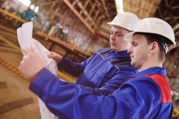 Engineer-builder working with documents on the construction site. Worker inspects drawings on the...