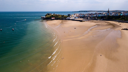 Boats stranded at low tide on a huge, sandy beach at a colorful, picturesque coastal town