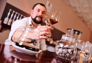 portrait of a handsome bearded barista preparing coffee on the background of a coffee shop and a coffee machine