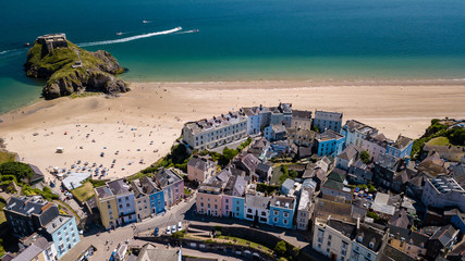 Aerial drone view of colorful buildings next to the ocean in a picturesque seaside town (Tenby,...