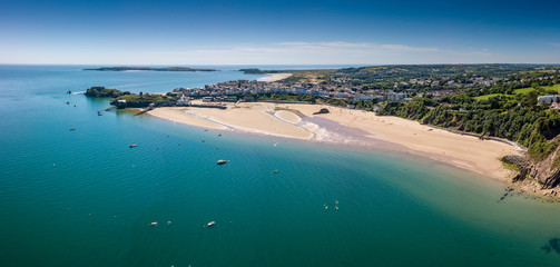 Aerial drone view of a beautiful coast town with sandy beaches and colorful buildings (Tenby, Wales, UK)