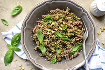 Delicious whole wheat pasta fusilli with basil pesto and pine nuts.Top view.