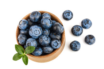 fresh ripe blueberry with leaf in wooden bowl isolated on white background. Top view. Flat lay pattern
