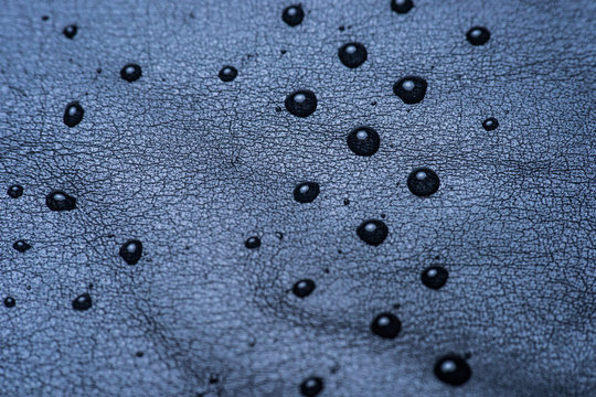 picture of some water drops on a black leather surface