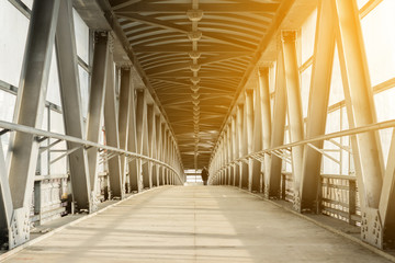 Modern overhead passage from steel and glass, perspective, long tunnel in sunset light