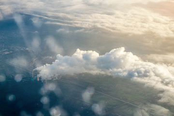 the plane flies in the clouds during sunset