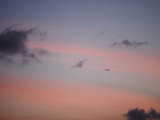 Fototapeta na wymiar pink purple sunset sky clouds with airplane silhouette 