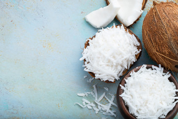 Coconut flakes in a shell on a blue background. top view with copy space