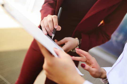 business women sign a contract or documents against the background of an office building