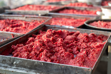 Close-up detail traditional handmade tomato paste making process shot under open air