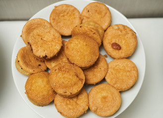 Cookies and sweet biscuits on white plate background, top view 