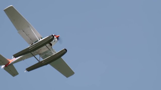 Close up of floatplane flying in blue sky