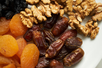 Mix of dry nuts and fruits. Composition with dried fruits and assorted nuts on white plates, top view