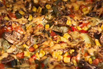 baked casserole with potato, mushrooms,onion, tomatoes and cheese on baking sheet. Selective focus