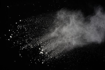 White powder explosion isolated on black background. Colored dust splatted.