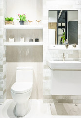 Modern spacious bathroom with bright tiles with toilet and sink.