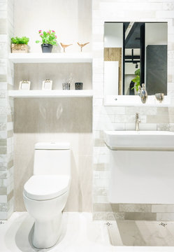 Modern spacious bathroom with bright tiles with toilet and sink.