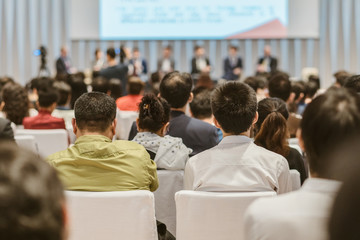 Obraz premium Speakers on the stage with Rear view of Audience in the conference hall or seminar meeting, business and education about investment concept