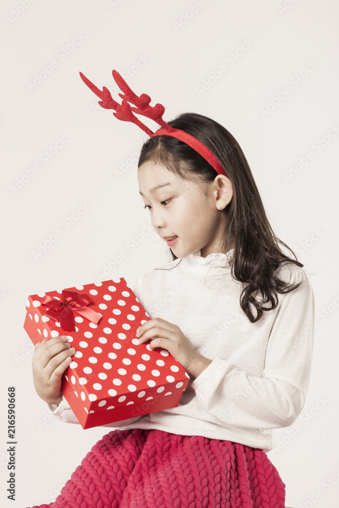 Wall mural A asian girl hand hold a christmas gift on the white background.