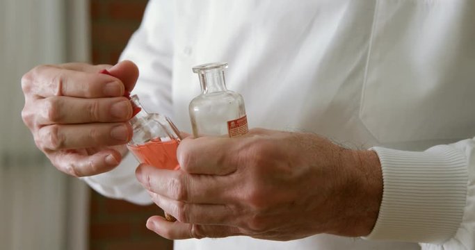vintage pharmacist adding chemicals to a bottle