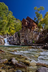Fototapeta na wymiar Crystal Mill, rustic old building outside Aspen, Colorado with waterfall, rushing stream and fall colors