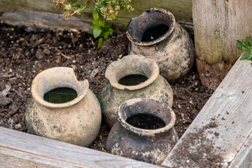 couple dirty empty jars in the garden in the shade