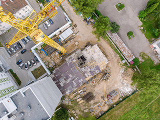 construction site in progress. top aerial view of building under construction and tower crane
