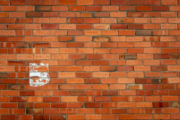 The number five painted onto a brick wall, faded and weathered due to time, number on left