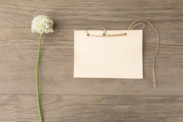 Wild garlic white flower with handmade craft notebook on old grunge wooden background. Top view. Minimalistic mockup.