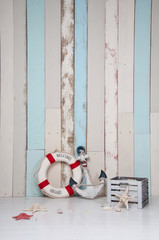 Obraz premium Composition on a marine theme with an anchor and life buoy, seashells and starfish on a wooden background