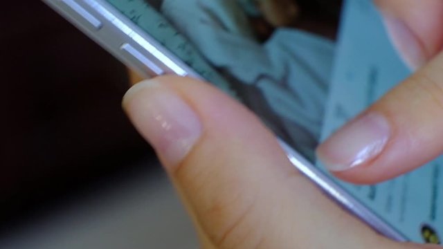 Woman looking at publicly shared photo on social network, pressing like button