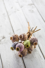 Poppy heads freely lying on a wooden board.